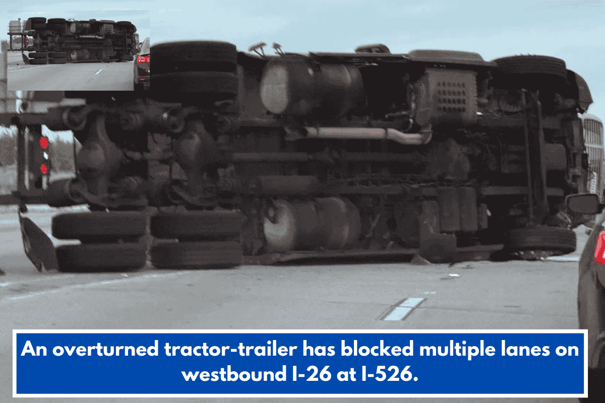 An overturned tractor-trailer has blocked multiple lanes on westbound I-26 at I-526.